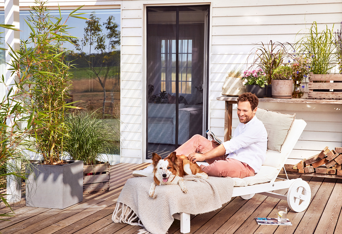 Απεικονίζεται άντρας να χαλαρώνει με τον σκύλο του. Πίσω φαίνεται η σήτα εγκατεστημένη.